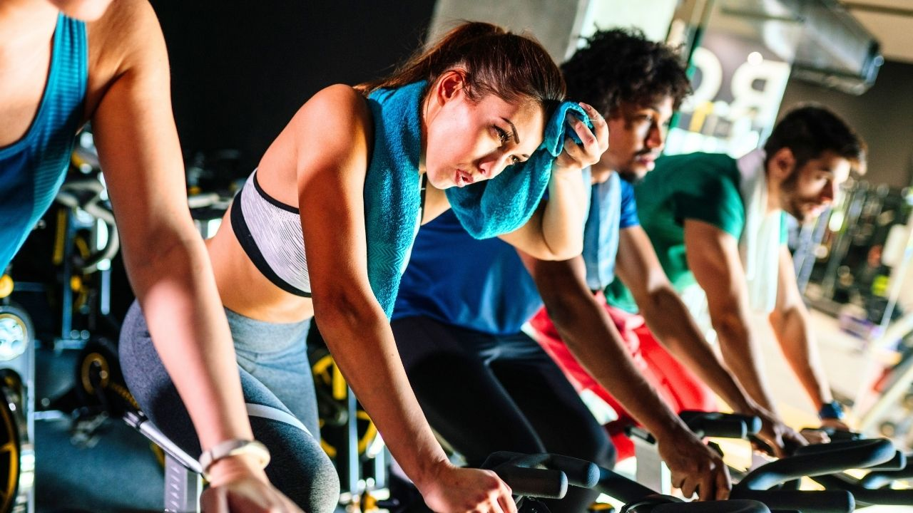 A group of people riding stationary bikes in a gym